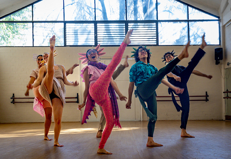 Ensayo de la compañía: el grupo en movimiento y una intérprete en arabesque